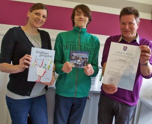 Mathematiklehrerin Rebekka Hofmeister und Realschulchef Günter Koch überreichen ihrem Top-Schüler Justin Kiese Siegertrophäen: Buch, Computerspiel, Urkunde.Bild: A. Bubrowski/CJD Oberurff